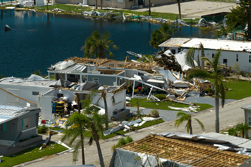 Collapsed and damaged mobile homes after hurricane Ian swept through Florida residential area. Consequences of severe natural disaster.