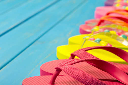 Colored thongs on a blue decking background with copy space