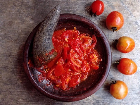 Raw chili sauce is made from various crushed raw ingredients such as shallots, chilies, tomatoes and mixed with shrimp paste. Indonesian chili sauce.