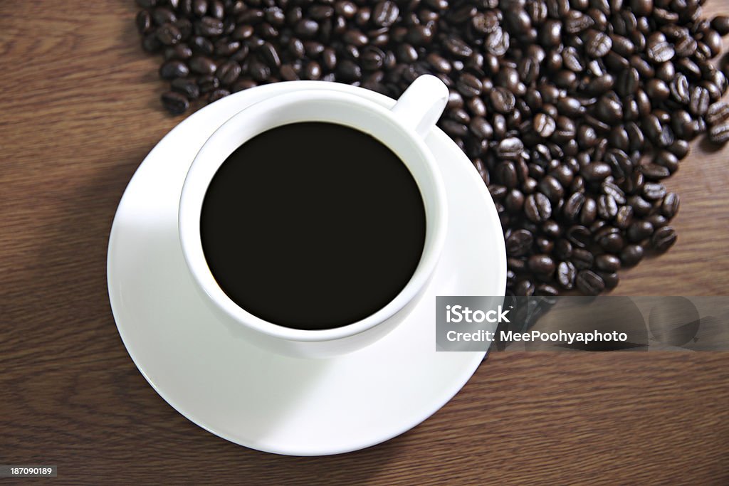 Taça branca e grãos de café na mesa de madeira. - Royalty-free Antigo Foto de stock