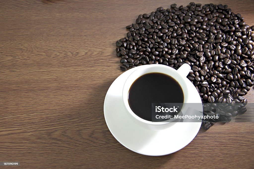 Copo branco e grãos de café na mesa de madeira velha. - Foto de stock de Amuado royalty-free