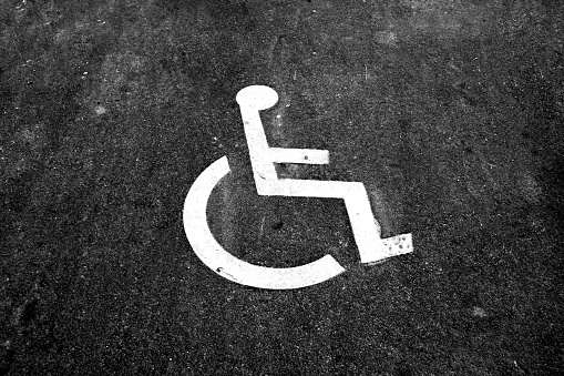 Rend and White painted handicapped sign traffic symbol on the floor in front of ramp way for support wheelchair