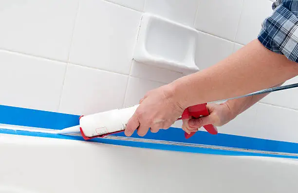 Caulking the bathroom tile.  Please see my portfolio for other home improvement images.