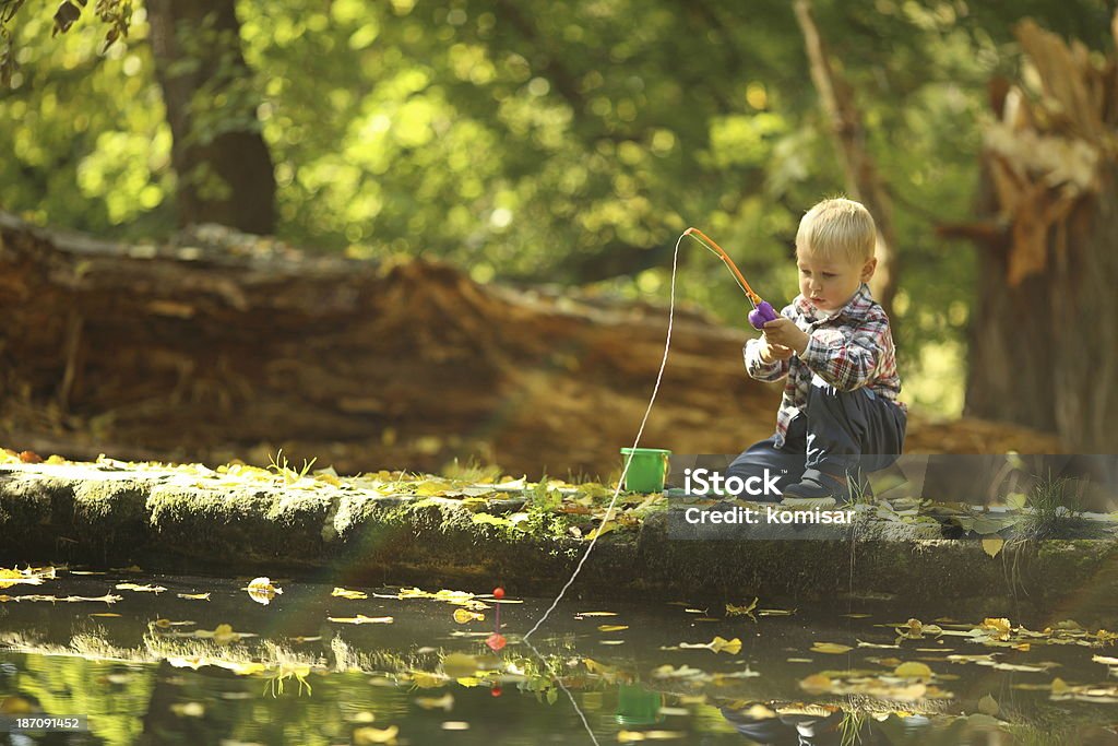 kid catches a fish kid catches a fish pond in the autumn Baby - Human Age Stock Photo