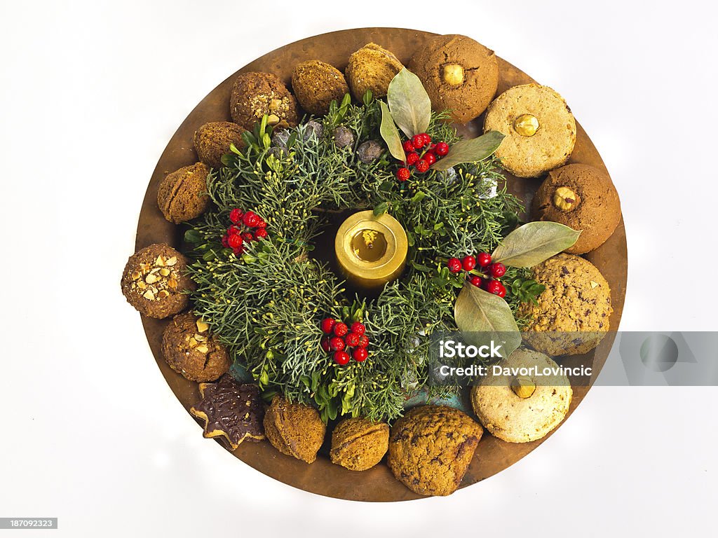 Christmas wreath Christmas wreath decorated with sweets, nuts on plate with golden candle.  Branch - Plant Part Stock Photo
