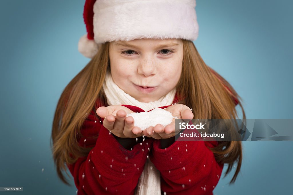 Bambina con Cappello da Babbo Natale e tenendo una manciata di neve - Foto stock royalty-free di 6-7 anni