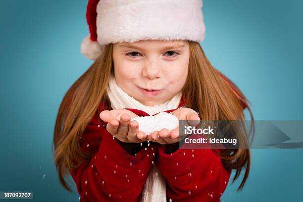 Menina Vestindo Chapéu Do Pai Natal E Segurando A Mão Cheia De Neve - Fotografias de stock e mais imagens de 6-7 Anos