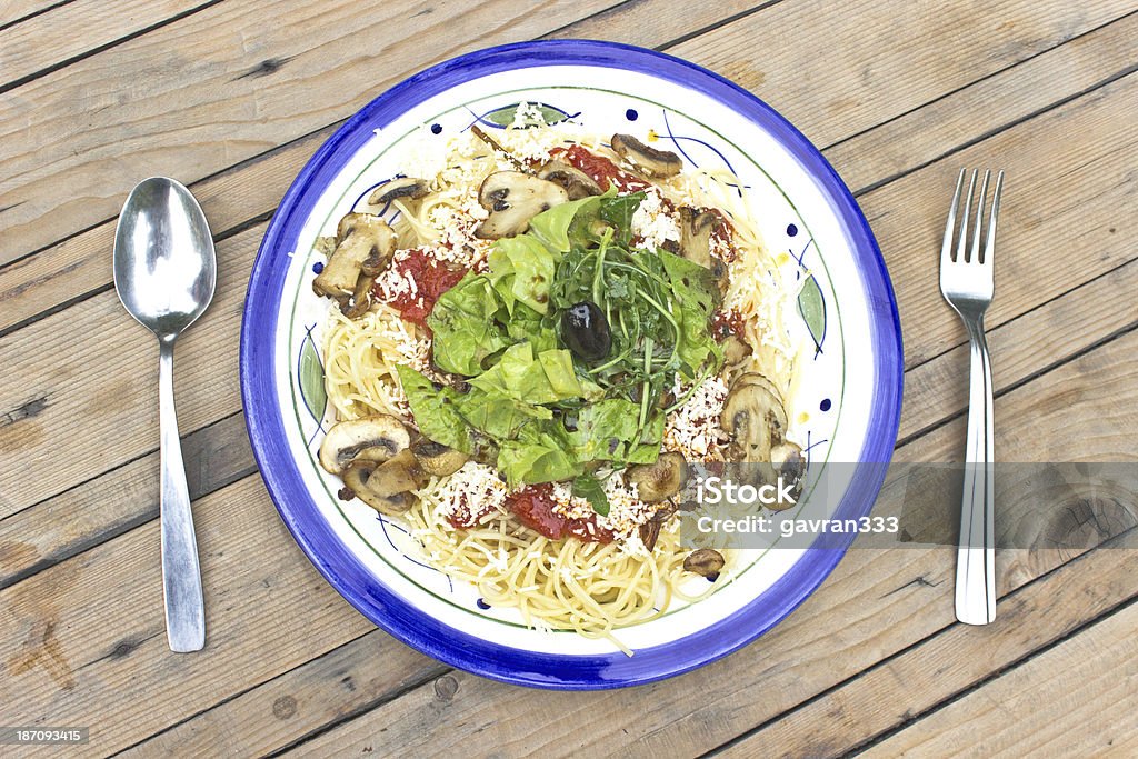 Spaghetti con funghi e verde erba su sfondo in legno - Foto stock royalty-free di Alimentazione sana