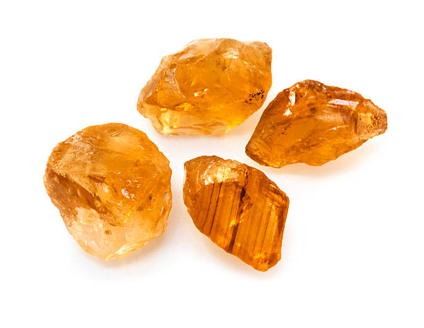 Raw unpolished citrine gemstones on the white background.  topaz stock pictures, royalty-free photos & images