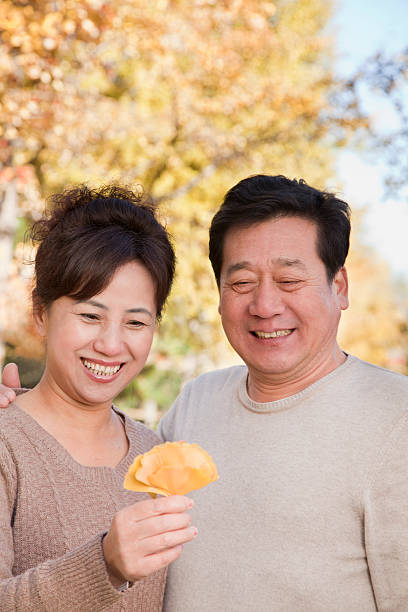 istock Mature Couple Looking at Leaf in the Park 187095887