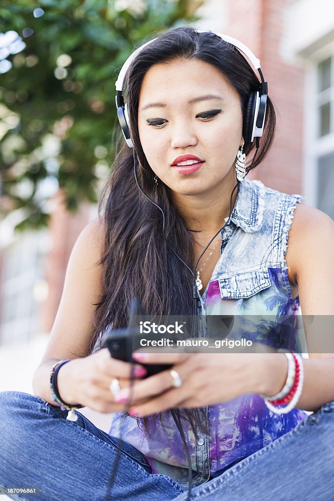 Giovane asiatica donna ascoltando musica da smartphone - Foto stock royalty-free di 18-19 anni