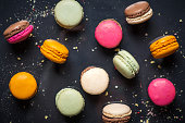 Multicolored french macaroons on dark background