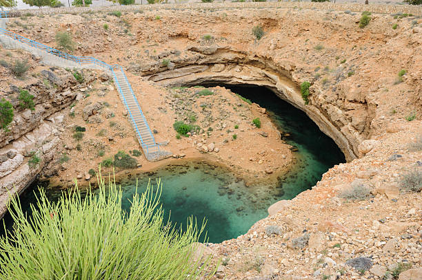 знаменитый оман карст - natural phenomenon hawiyat najm park cliff cave стоковые фото и изображения