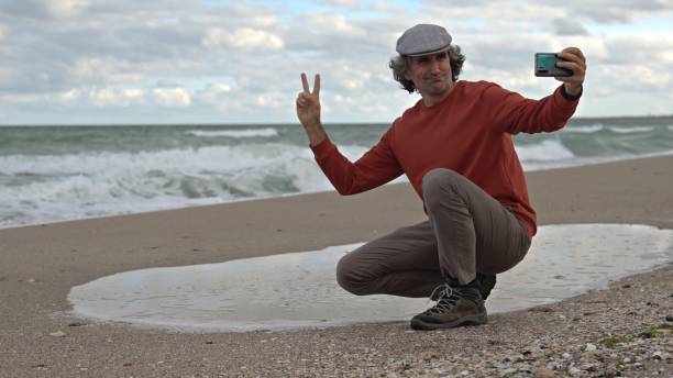 istock Man by the sea, taking selfie and photographing. copy space 1871005008