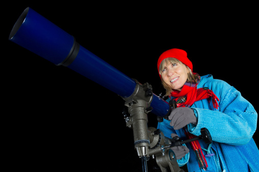 Adult woman observing the night sky using a three inch refracting telescope. More astronomy themes in this lightbox: