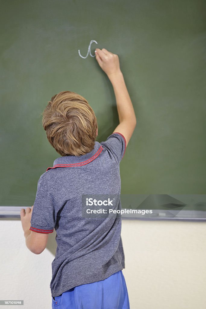 Expanding his mind A young boy writing on the blackboard at school 10-11 Years Stock Photo