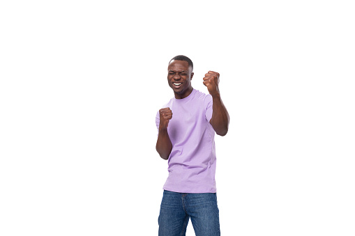 young happy joyful cute african man in lilac t-shirt laughing on white background.