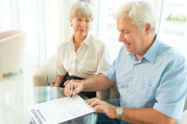 Elderly couple purchasing life insurance Smiling senior couple buying insurance term life insurance for seniors to help with other financial demands stock pictures, royalty-free photos & images