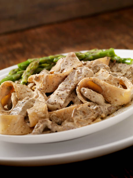 Beef Stroganoff Beef Stroganoff with Beef Tenderloin, Mushrooms, Thick Noodles and Asparagus - Photographed on Hasselblad H3D2-39mb Camera cooked selective focus vertical pasta stock pictures, royalty-free photos & images