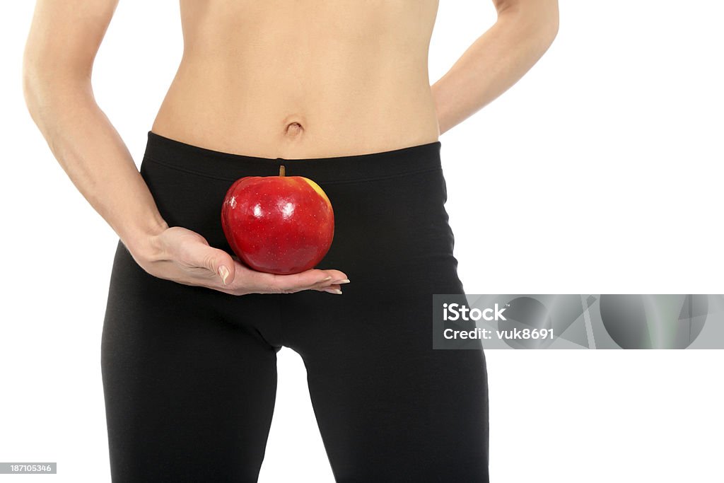 Healthy lifestyle Fit woman holding an apple in front of white background Abdomen Stock Photo
