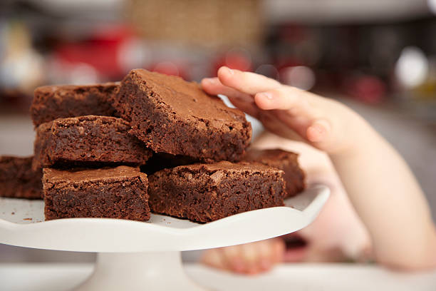 grabbing a brownie stock photo