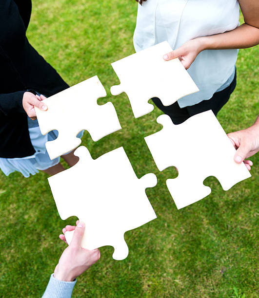 istock Four people teamwork and connect jigsaw puzzle 187105958