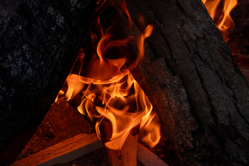 Tappahannock, Virginia, USA - A fire in an outdoor fire pit on a riverbank overlooking the Rappahannock River