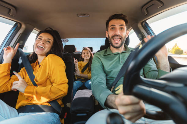 we are going on vacation. happy family of three driving in their automobile, dancing to music and singing - image singing fun vacations imagens e fotografias de stock