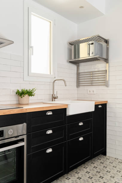 istock Silver microwave oven, sink and cabinets in modern kitchen 1871081633