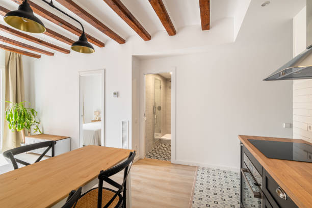 istock View from the modern dining kitchen with a loft interior and cozy furniture with high-tech appliances to the hallway and bathroom in light white tones. Concept of a new house and Scandinavian interior 1871081689