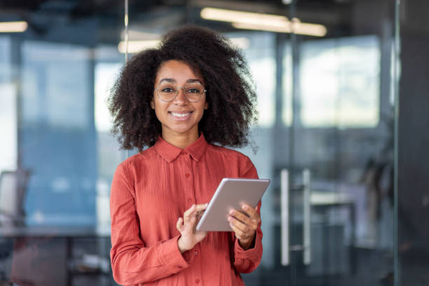 istock Portrait young successful businesswoman with tablet computer in hands inside office at workplace, female programmer testing new software smiling looking at camera satisfied with achievement results 1871081903