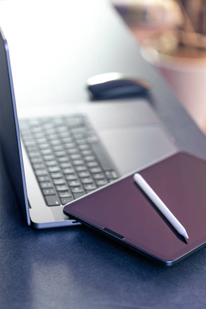 istock Digital tablet, stylus pen and laptop on the desktop, close up. 1871082432