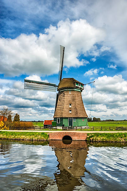 tradicional moinho holandês em uma típica canal em países baixos - polder windmill space landscape imagens e fotografias de stock