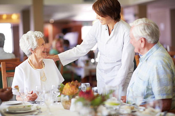está a desfrutar a refeição? - senior adult nursing home eating home interior imagens e fotografias de stock
