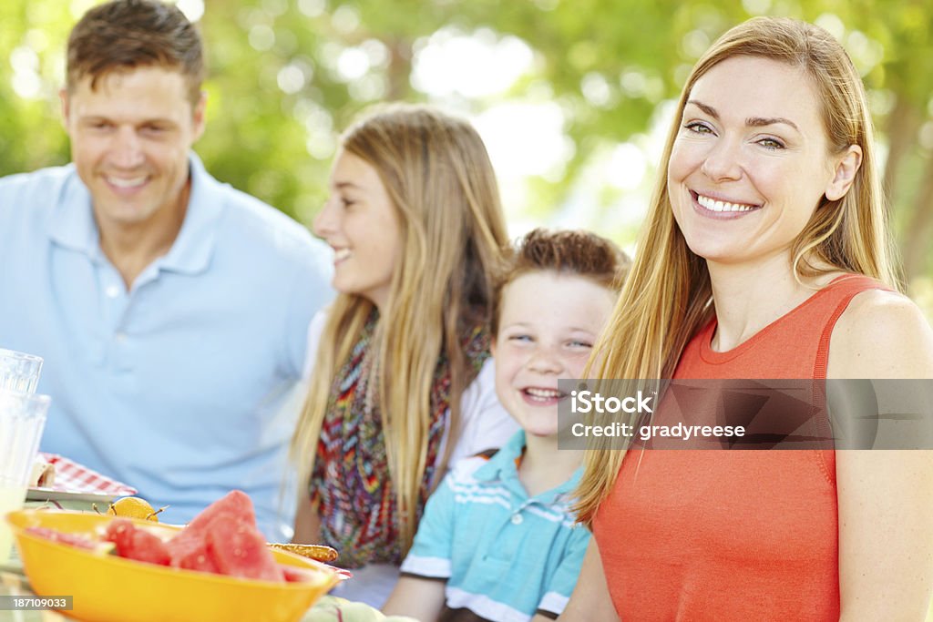 Having a family is so fulfilling! A happy young family relaxing in the park and enjoying a healthy picnic 40-49 Years Stock Photo