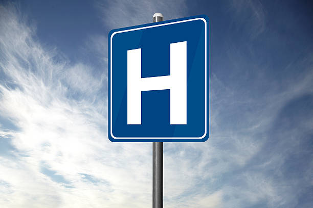 Hospital road sign standing alone with clouds overhead stock photo