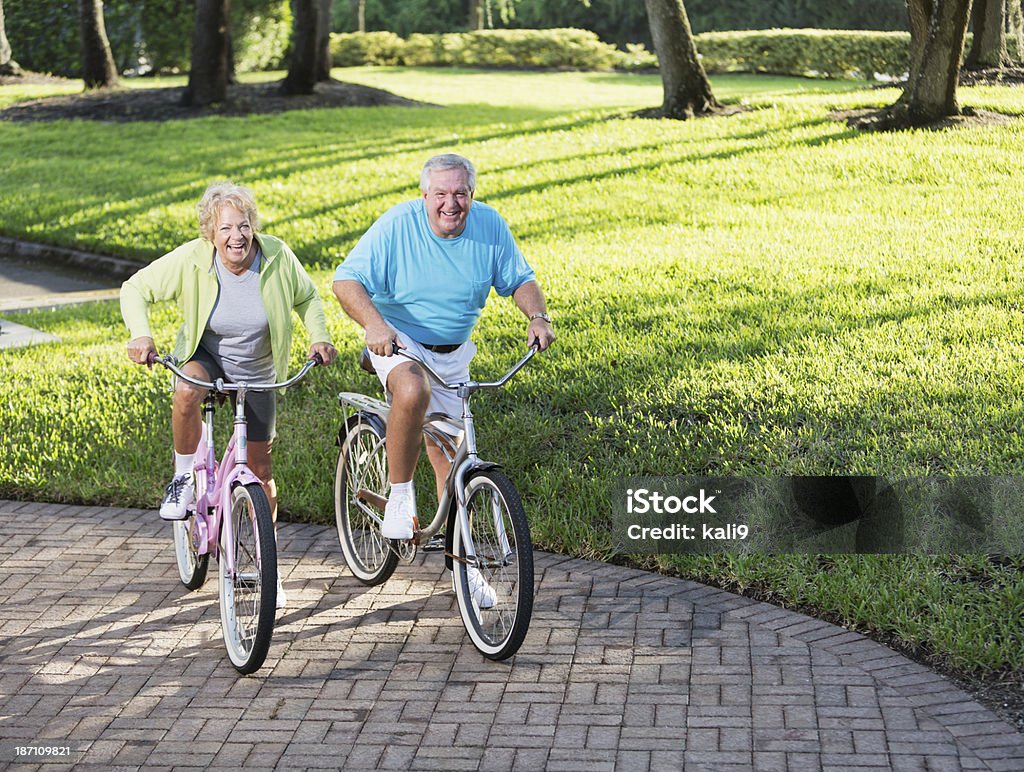 Senior couple riding bicycles Senior couple (60s, 70s) riding bicycles. 60-64 Years Stock Photo