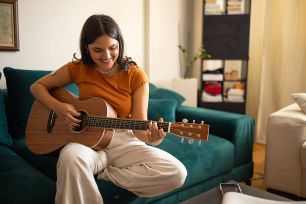 istock Young woman playing guitar 1871102087