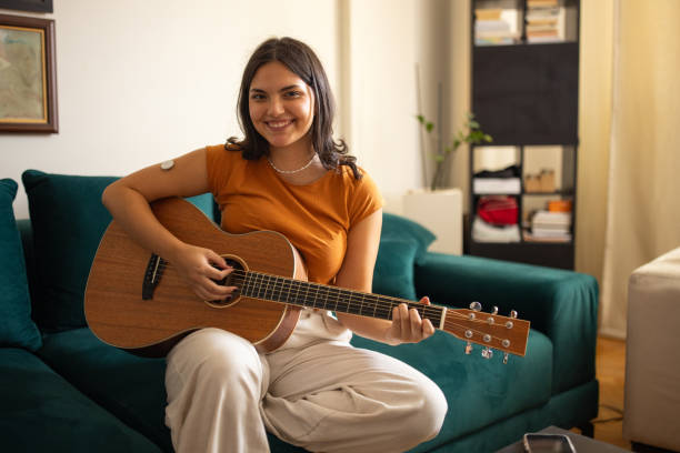 istock Young woman playing guitar 1871102745
