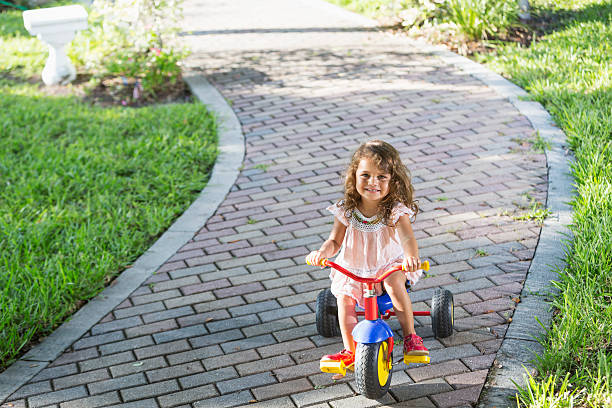 istock Little girl riding tricycle 187110835