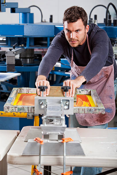 человек рабочий экран печати оборудование - young men printing plant printing press factory стоковые фото и изображения