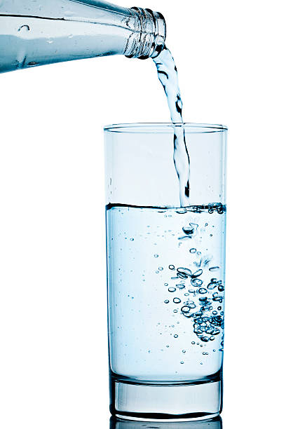 水のガラス - overflowing water glass bottle ストックフォトと画像