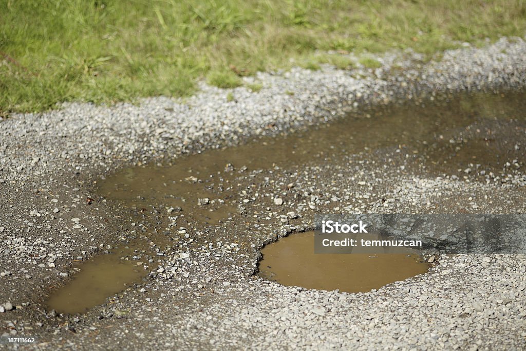 Livello di superficie vista di acqua in una pentola riempita di fori strada. - Foto stock royalty-free di Asfalto