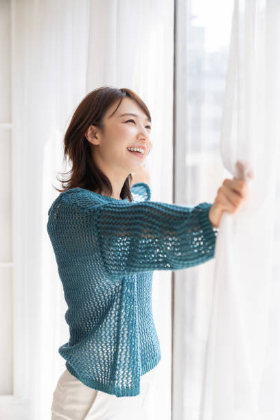 istock attractive asian woman relaxing,open the curtains 1871119866