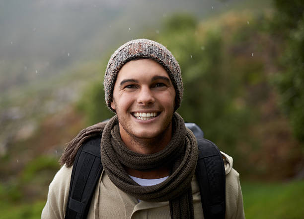 Portrait of a handsome young man standing in the mountains