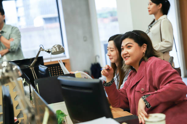 istock business employees are discussing the project plan while seated at their office desks. 1871130989
