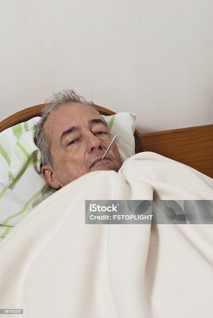 Плохо человек с грипп в постель - Стоковые фото 55-59 лет роялти-фри