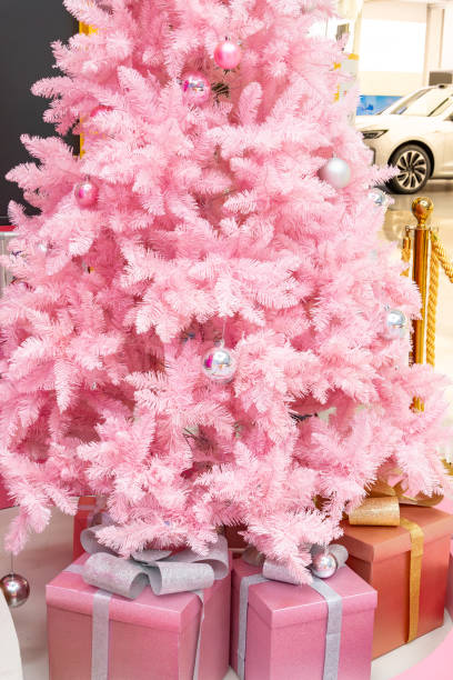 part of a pink Christmas tree with gift boxes at vertical composition