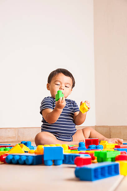 istock Cute Latino toddler playing building blocks 187115288