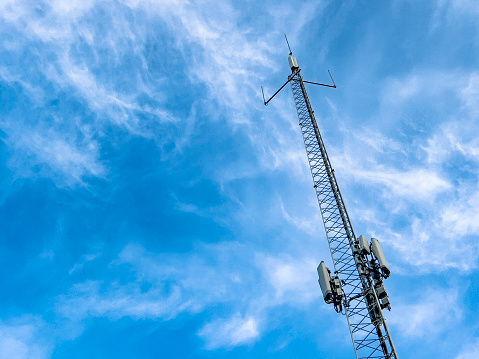 Looking up at a 5G telecommunications base station tower. Mobile telephone network. Cell site or mobile phone site, electronic communications equipment, radio mast, digital signal processors.  Technology background with copy space.